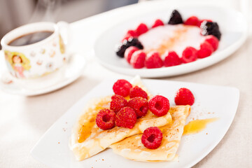 breakfast of pancakes with fresh raspberries on table