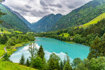 Fototapeta na wymiar Klamsee - mountain water reservoir above Kaprun town with bright turquoise blue water, Austria