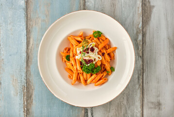 Penne pasta in tomato sauce with  cheese, tomatoes decorated with parsley
