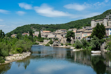 Fototapeta na wymiar View of the Ardeche river banks with clouds reflecting in the water at french medieval Vogue village.
