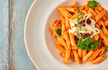 Penne pasta in tomato sauce with  cheese, tomatoes decorated with parsley