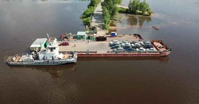 Aerial view of a typical Russian ferry boat transport cars and people. Aerial top view ship sails on the river Kama, Perm krai, Russia. Car and boat transportation on the sea, river, ocean and water.