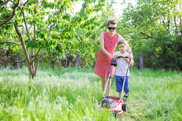 Mother and son mowing grass with lawnmower