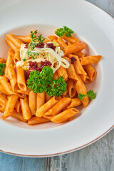Penne pasta in tomato sauce with  cheese, tomatoes decorated with parsley