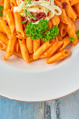 Penne pasta in tomato sauce with  cheese, tomatoes decorated with parsley