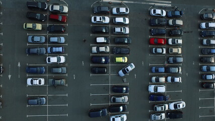 Drone footage people moving at parking. Aerial view car leaving parking
