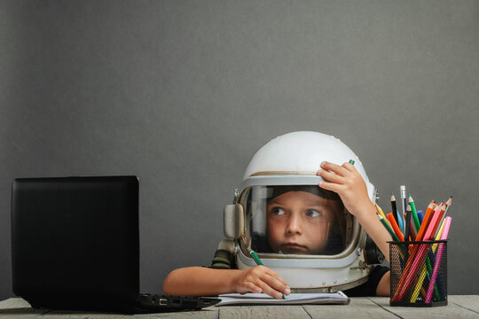 the child studies remotely at school, wearing an astronaut's helmet. back to school
