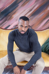 Pensive handsome black man sitting on a couch