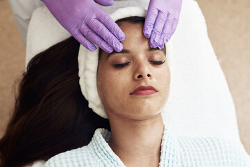 Fototapeta na wymiar Young woman having anti-stress facial massage in salon at spa resort. Face massage. Facial skin care. Woman at beauty spa salon