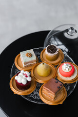 several cakes of different colors on a glass stand