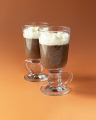 Coffee Chia pudding in glass on brown - orange color background.