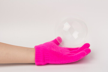 Child in brighte gloves holding soap bubble. happy childhood