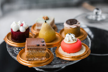 several cakes of different colors on a glass stand