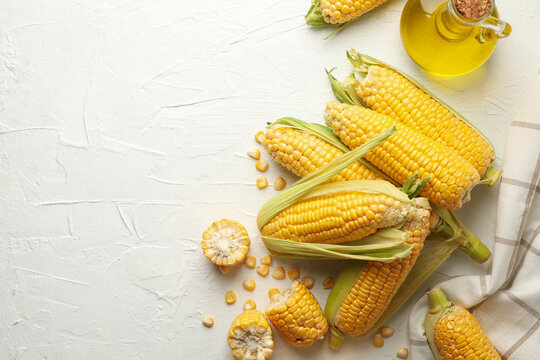 Composition with fresh raw corn on white background, top view