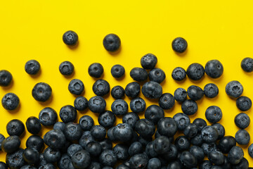 Delicious fresh blueberry on yellow background, top view