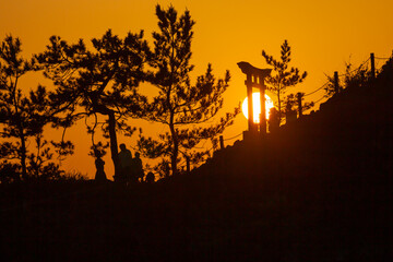 夕日の中で祈る人々