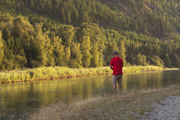 Fototapeta na wymiar Man fishing on river bank Montana 