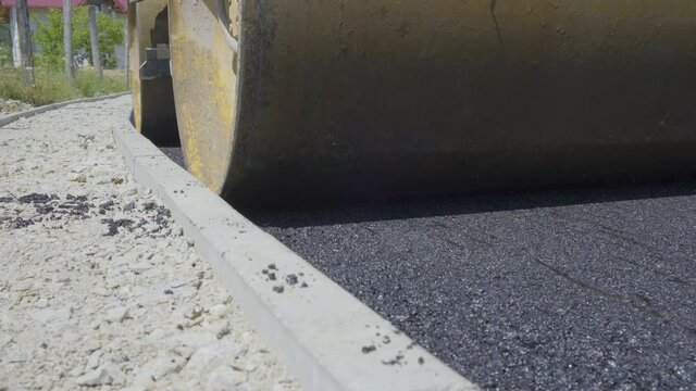 Asphalt paving. Steamroller compacting fresh layer of asphalt