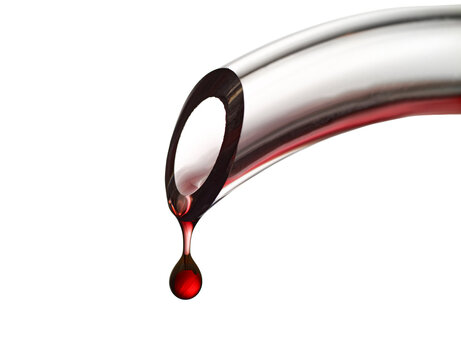 Drop of red wine falling on white background