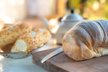 Cafe table with breads, crackers and accessories with blurred background, natural light on white table, selective focus