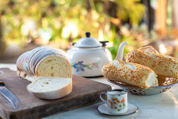 Cafe table with breads, crackers and accessories with blurred background, natural light on white table, selective focus