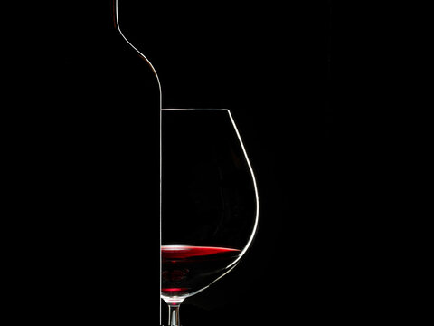 Silhouette of wine glass and bottle on black background