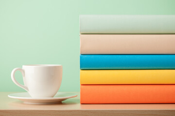 Stack of books and cup on wooden table