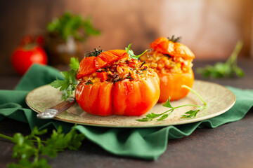 Delicious stuffed tomatoes in shape of pumpkin with rice, vegetables and meat. Concept homemade healthy eating.