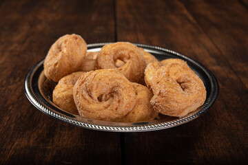 sweet cookies in a stainless steel container on rustic wood, selective focus