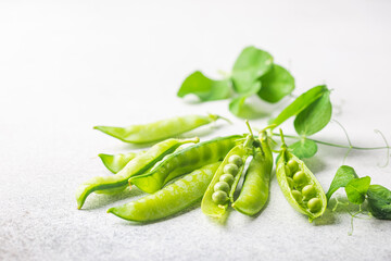 Pods of green peas on a white background close up, soft focus