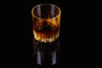 Glass of whiskey on a black background