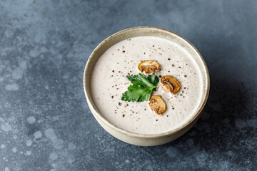 Mushroom cream soup on dark background. Champignon soup
