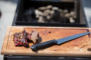 Cutting board, knife and slices of meat.