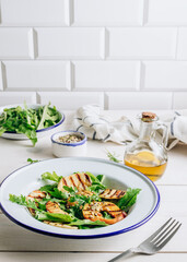 Grilled Halloumi Cheese salad with peach and arugula on a white wooden background. Healthy food concept. Selective focus. Vertical photo