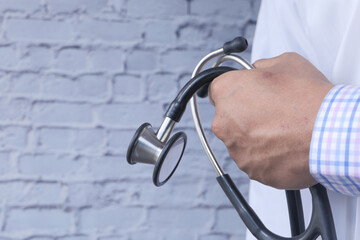 close up of doctor with arms crossed and stethoscope on hand 
