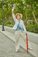 White cheerful elderly woman is travelling.