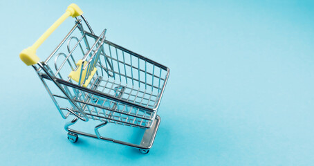 high angle view of miniature shopping cart on blue background