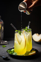 Melon juice, lemonade in glasses with ice and melon slices garnished with basil leaves. Concept of fresh summer drink