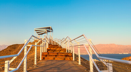 Scenic point of view on the Red Sea and vicinity of desert area, decorative public pergola on top and safe walkway to the stone summit, Middle East