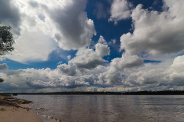 Obraz premium River and shore against the background of clouds