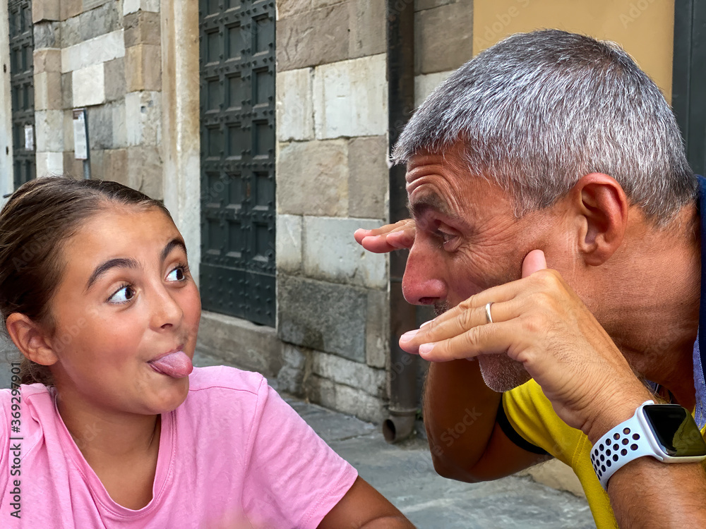 Sticker young girl making grimaces with her father outdoor