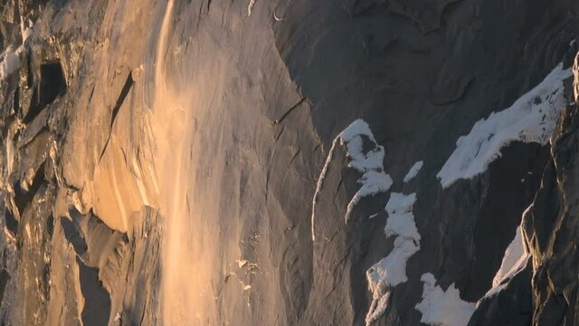 Telephoto shot of Firefall-- seasonal Horsetail Falls illuminated by evening sunlight in Yosemite National Park, California