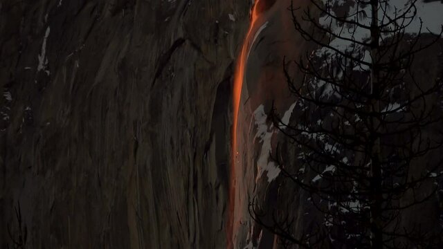 Tilt down shot of Firefall-- seasonal Horsetail Falls illuminated by evening sunlight in Yosemite National Park, California