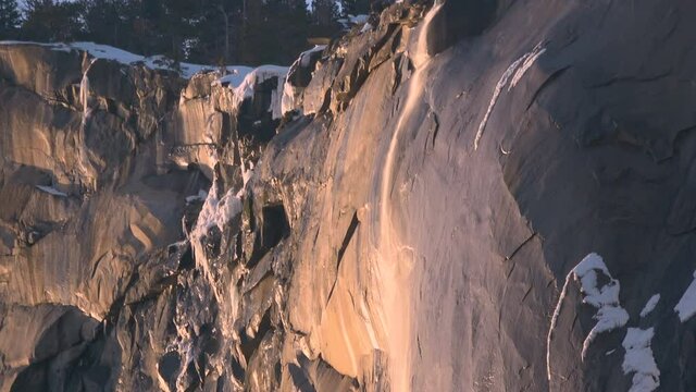 Telephoto shot of Firefall-- seasonal Horsetail Falls illuminated by evening sunlight in Yosemite National Park, California