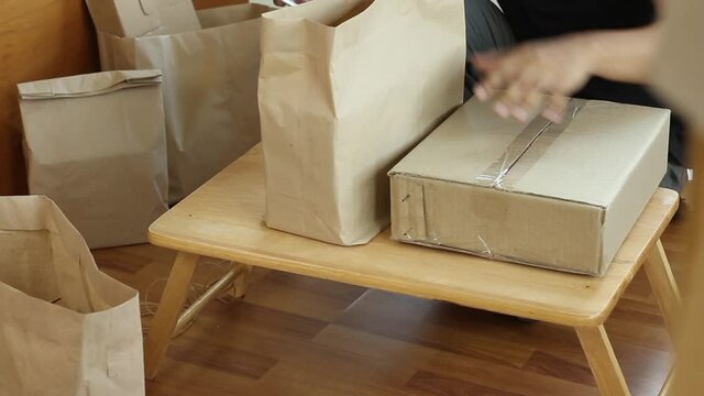 Online businessman checking order list on mobile phone and prepare many package box to customer
