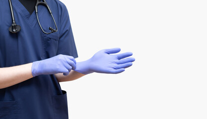 A doctor in a blue uniform putting on sterile gloves on a white background. Banner.