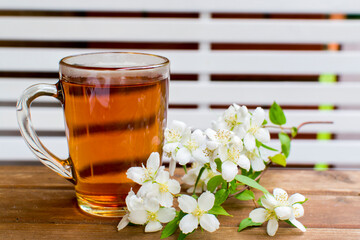 Herbal tea with flowers on rustic wooden table. Summer tea menu.