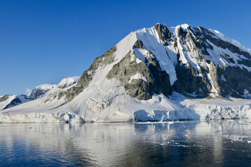 Antarctic landscape, glacier and mountain, with reflection in water, Antarctica