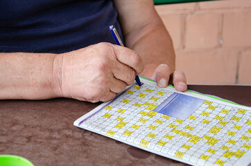 Fototapeta na wymiar Someone is solving crossword puzzle for fun.