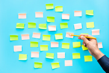 Businessman with colorful notepaper on blue  background